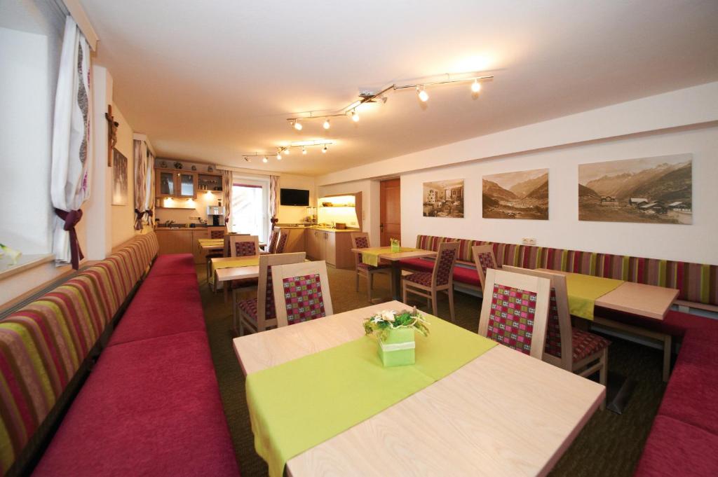 un restaurante con mesas y sillas y un sofá en Pension Pitze, en Sölden