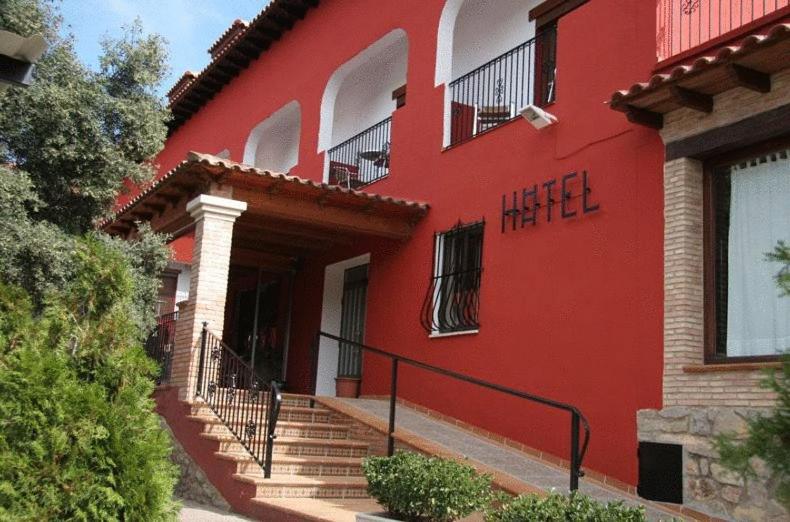 a red building with stairs in front of it at Hotel La Rueda in Mora de Rubielos