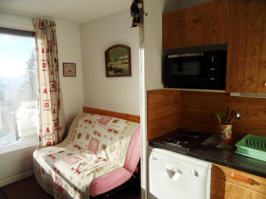 Habitación pequeña con mesa pequeña y cocina en Studio Chamrousse, 1 pièce, 4 personnes - FR-1-340-253 en Chamrousse