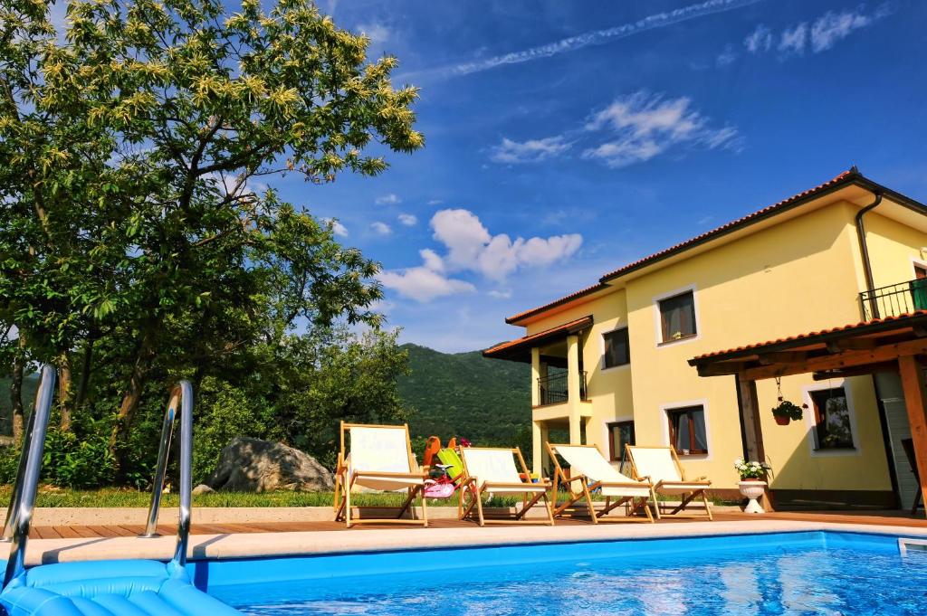 a woman sitting in chairs next to a swimming pool at Apartment Kalina Hills in Ičići