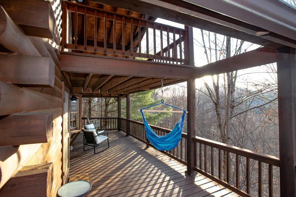 a hammock on the deck of a cabin at Treetops Cabin easy to Asheville with fast wifi and great view in Swiss