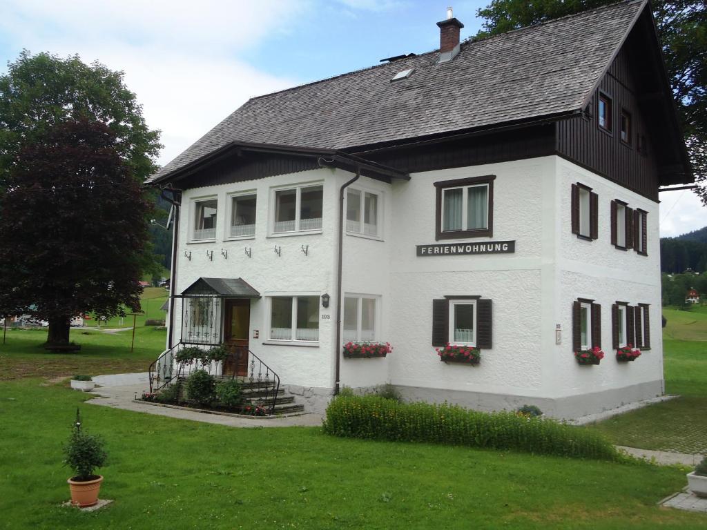 ein weißes Haus mit schwarzem Dach in der Unterkunft Haus Grünwald in Gosau