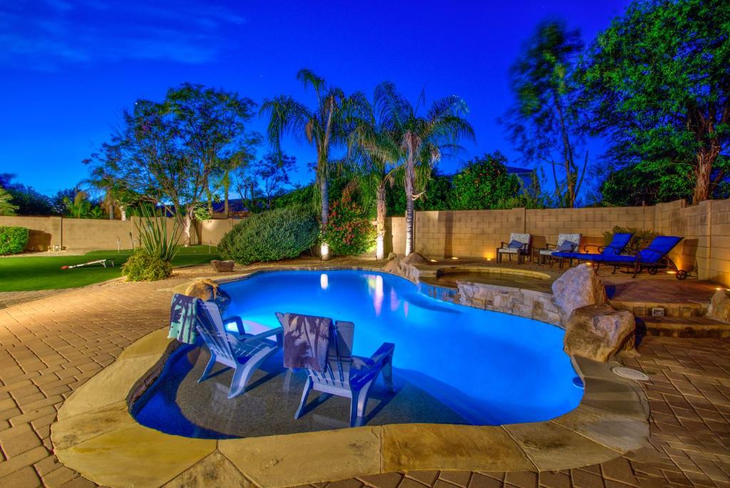 a swimming pool with two chairs and a table at Laguna Sonora in Phoenix