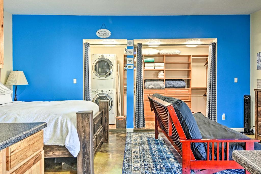 1 dormitorio azul con 1 cama y lavadora en Albuquerque Studio with Shared Pool and Fire Pit!, en Albuquerque