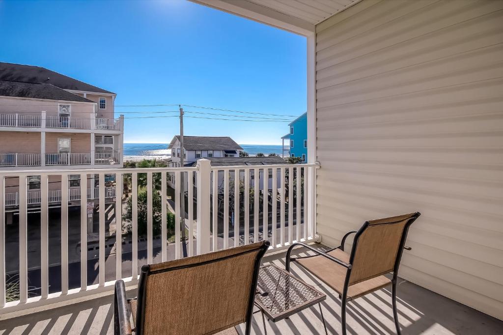 2 stoelen op een balkon met uitzicht op de oceaan bij Coconut Grove 203 in Myrtle Beach