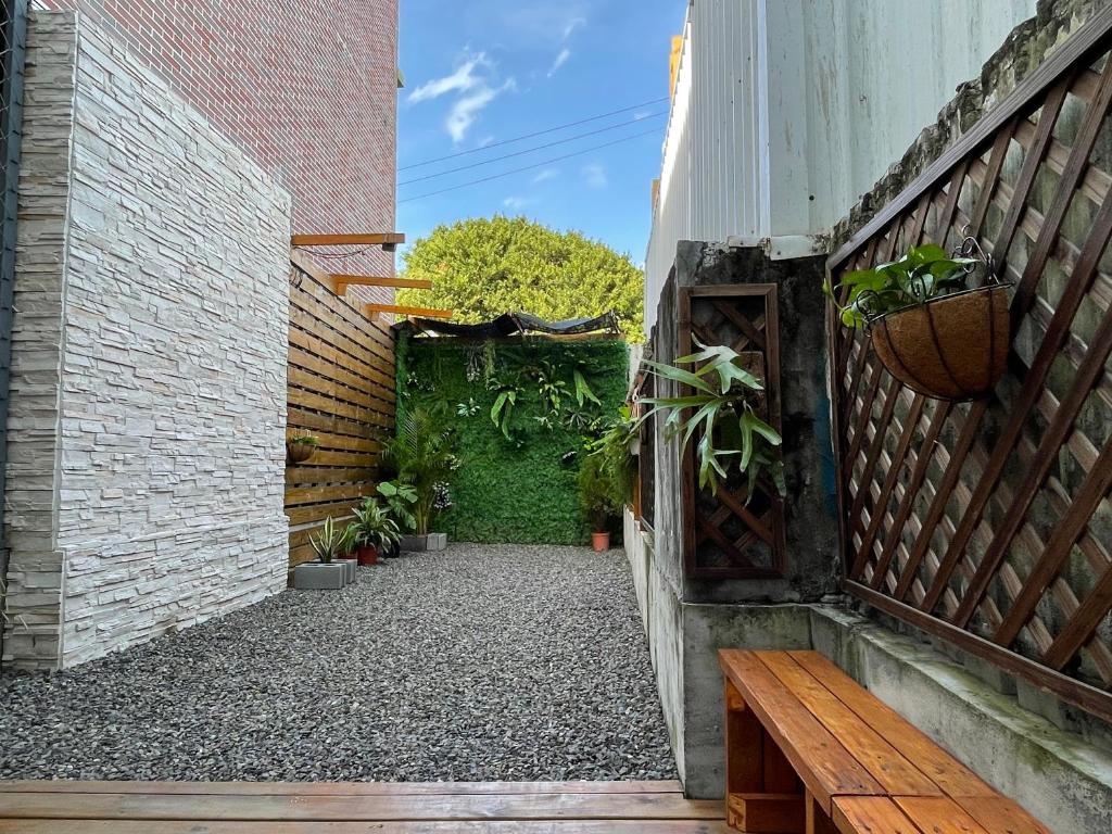 a courtyard with a bench and a green hedge at 墾丁星院旅宿 in Kenting