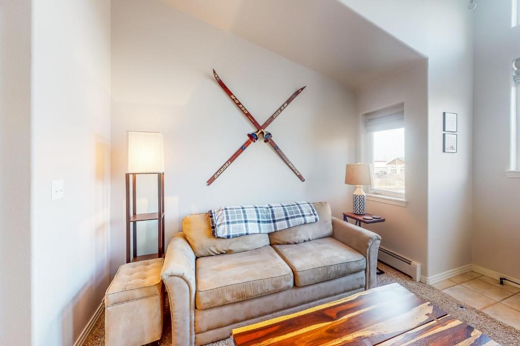 a living room with a couch and a clock on the wall at At the Crossroads in Frisco