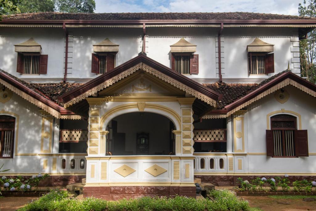 una casa vieja con un arco delante de ella en Gileemale Walawwa & Estate en Ratnapura