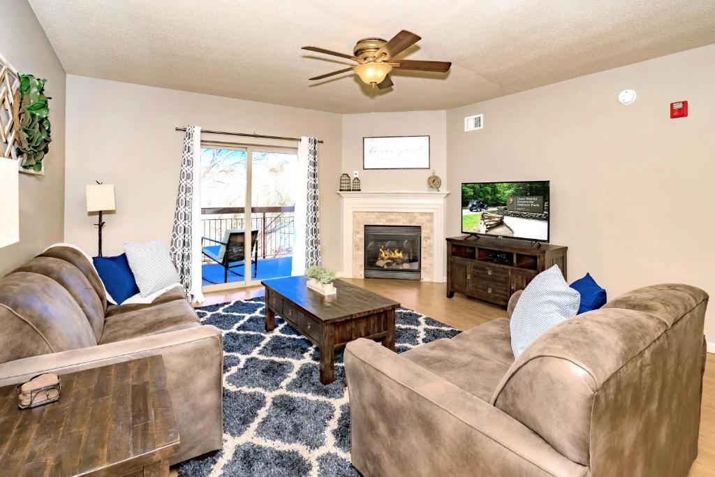 a living room with two couches and a tv at Cedar Lodge in Pigeon Forge