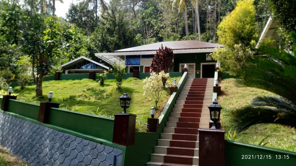 a house with a staircase leading up to it at Fab Valley Homestay in Munnar
