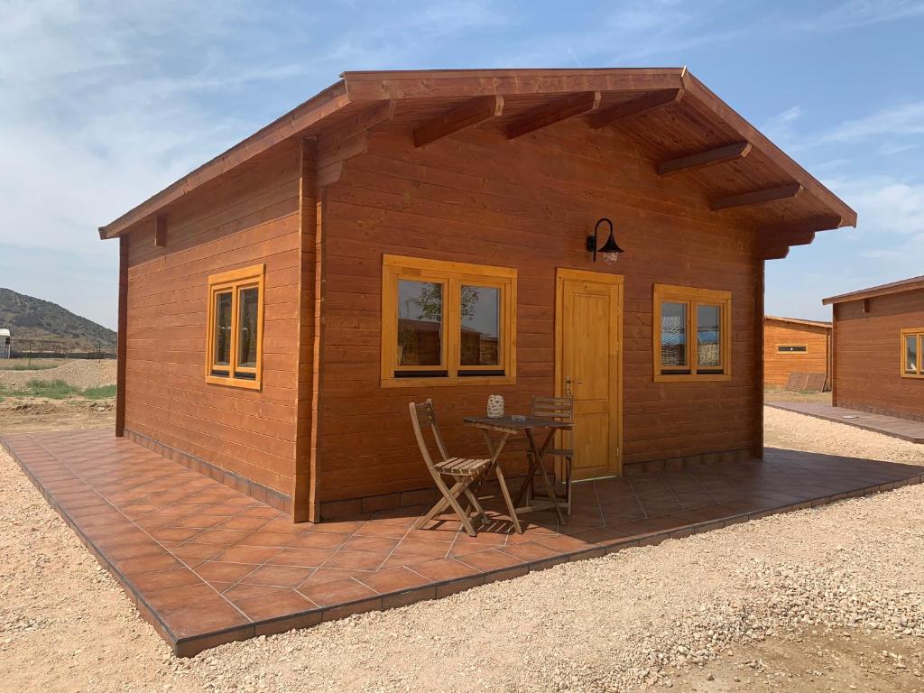 a small wooden house with a table and chairs at Granja escuela con Bungalows in San Martín de la Vega