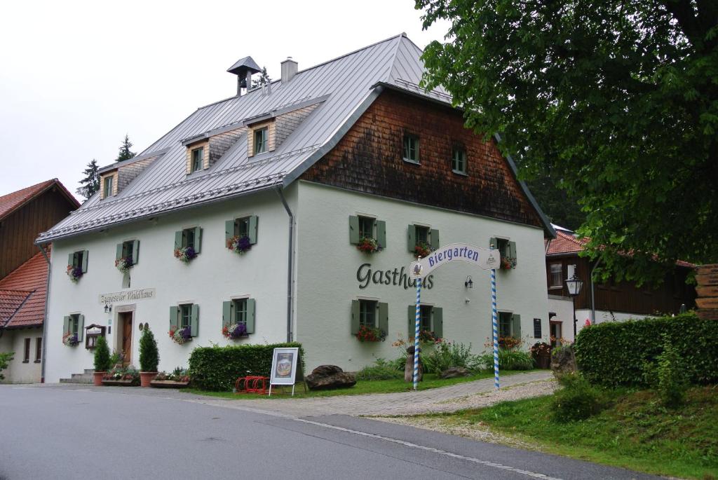 ein großes weißes Gebäude mit einem Gamer-Dach in der Unterkunft Zwieseler Waldhaus in Lindberg