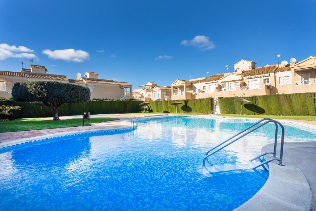 una gran piscina en un patio con casas en Tara 2 bed Townhouse in Torrevieja, en Torrevieja