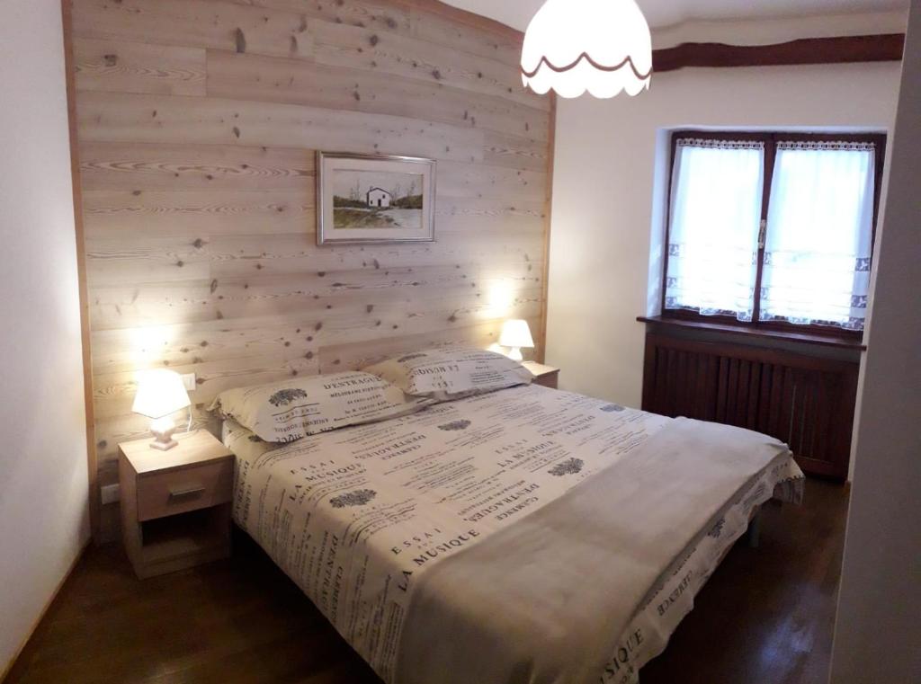 1 dormitorio con 1 cama con pared de madera en Relax a Cortina d'Ampezzo - Alverà, en Cortina dʼAmpezzo