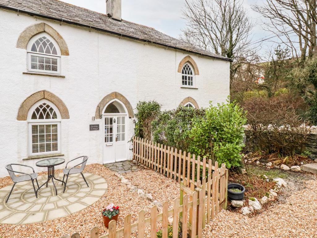 a white house with a table and chairs in front of it at Destiny Cottage in Boscastle