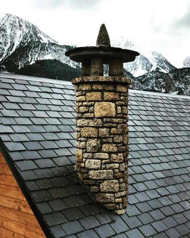 a brick chimney on the roof of a house at Casa Albana Pirineos in Gistaín