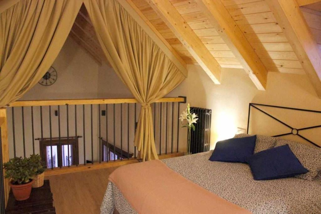 a bedroom with a bed with curtains in it at Casa Albana Pirineos in Gistaín