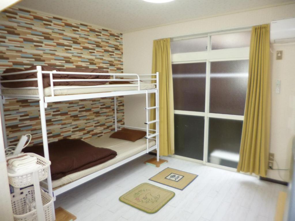 a bedroom with two bunk beds and a window at ザミッキーカールトン井尻102 in Shiobaru
