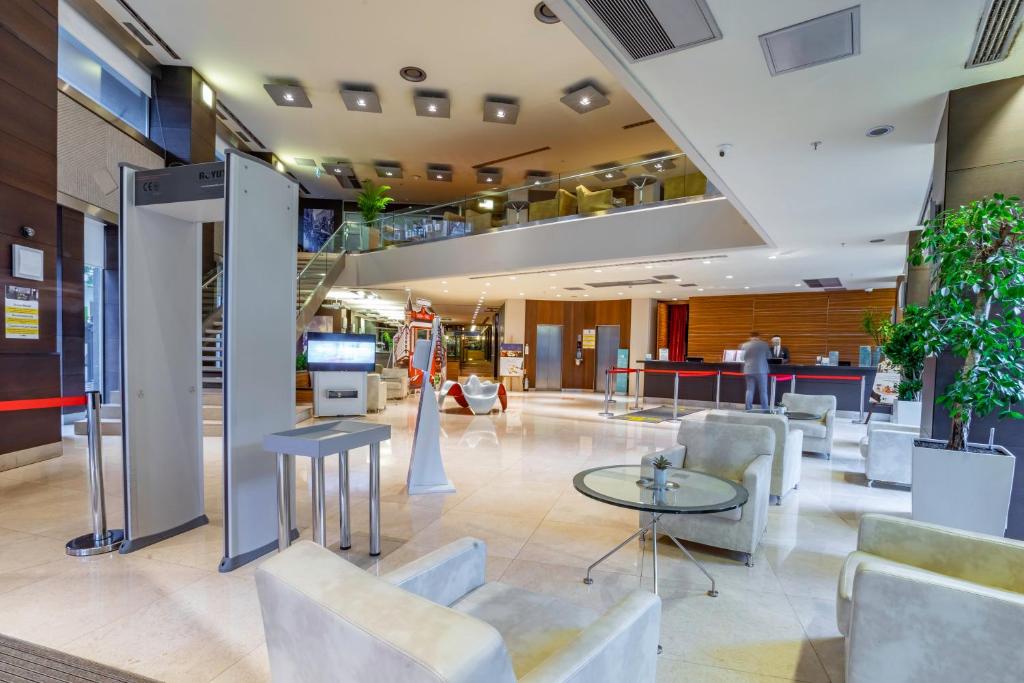 a lobby of a hotel with white chairs and a table at Point Hotel Taksim in Istanbul