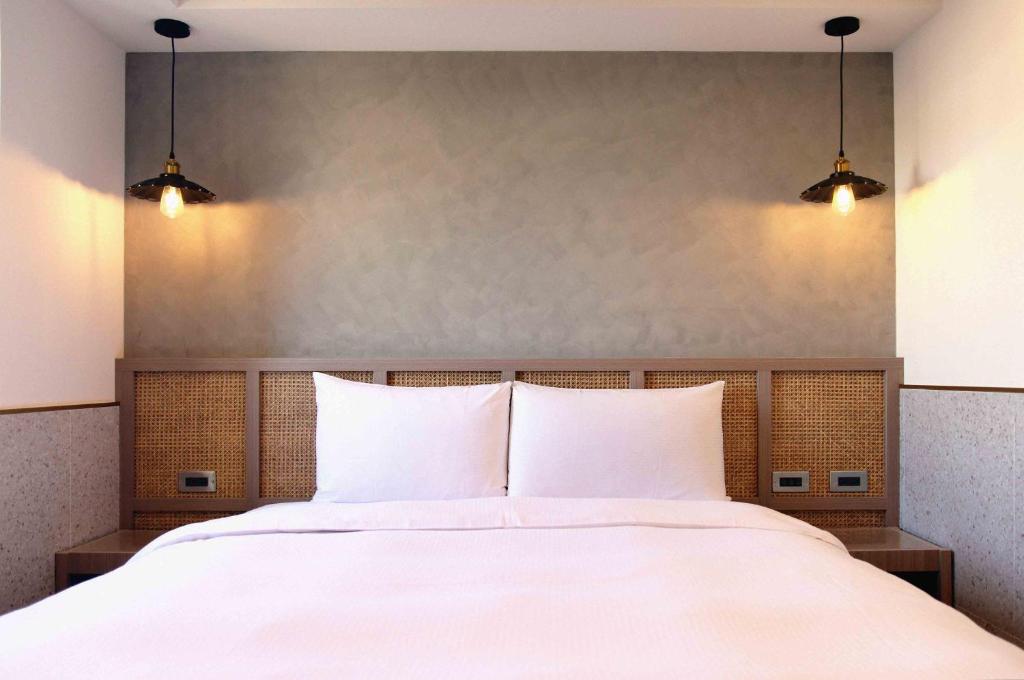 員林的住宿－康橋商旅- 員林館，卧室配有一张带两个灯的大白色床