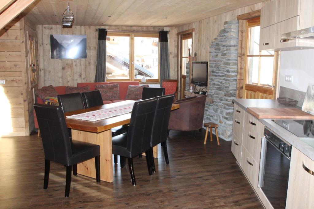 a kitchen and dining room with a table and chairs at Chalet Pomme de Pin in Tignes