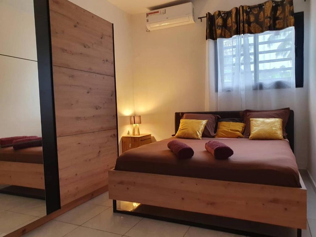 a bedroom with a bed and a large window at l'annexe by l'auberge de l'île in Dzaoudzi