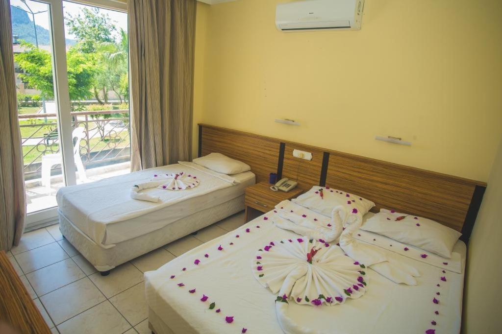 2 łóżka w pokoju hotelowym z oknem w obiekcie KEMER STAR HOTEL w mieście Kemer