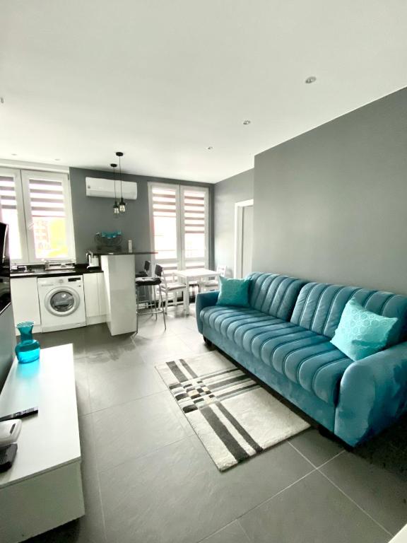 salon z niebieską kanapą i kuchnią w obiekcie D&M Apart Lipowa 12 w mieście Białystok