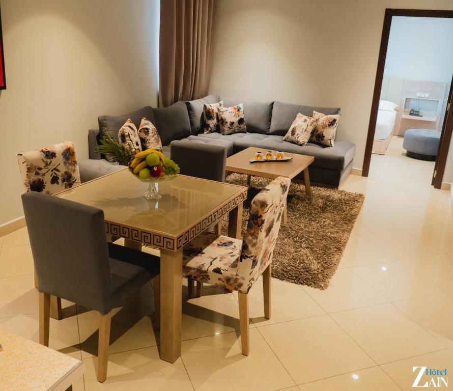 a living room with a table and a couch at Zain Hotel in M'diq