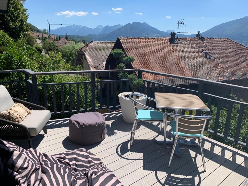 een terras met een tafel en stoelen op een balkon bij Angel Services - LE COTTAGE DE VEYRIER in Veyrier-du-Lac