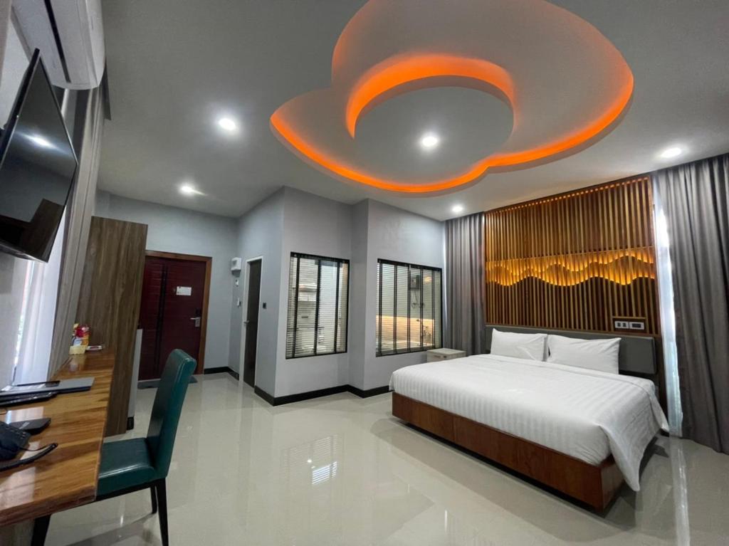 een slaapkamer met een groot bed en een groot plafond bij Phutara Resort and Spa in Buriram