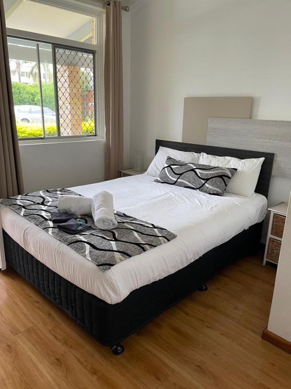 a large bed in a bedroom with a window at Forster and Wallis Lake Motel in Forster