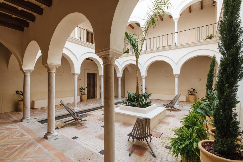 an indoor courtyard with a fountain in a building at Casa del Rey Sabio in Seville