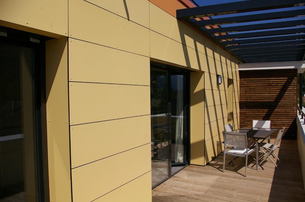 un patio avec une table et des chaises à côté d'un bâtiment dans l'établissement Angel Services - Les Mouettes, à Annecy
