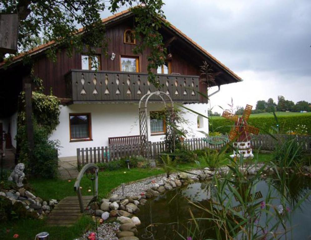 a house with a pond in front of it at Ferienwohnung Herold in Wessobrunn