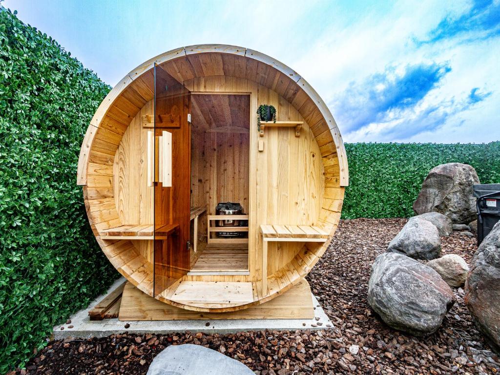 uma sauna circular de madeira com uma porta redonda de madeira em The Grey Straw House - Rangataua Holiday Home em Ohakune