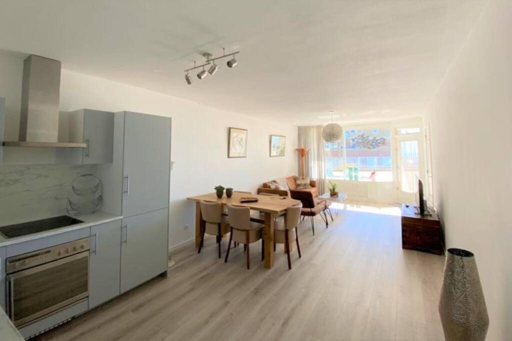een keuken en een woonkamer met een tafel en stoelen bij Witte Jade in Egmond aan den Hoef
