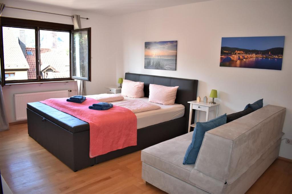 ein Schlafzimmer mit einem Bett und einem Sofa in der Unterkunft Altstadtblick in Heidelberg