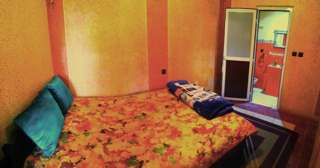um quarto com uma cama com folhas em Room in Guest room - Gite Tawada - Happy Valley - Room for 2 People em Agouti
