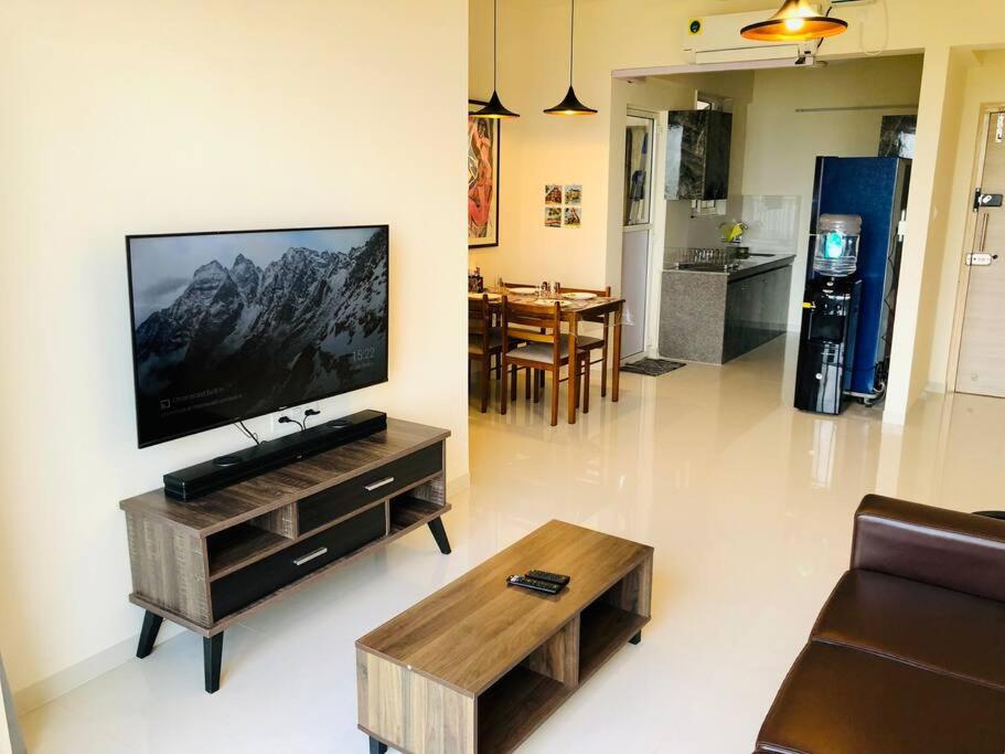 ein Wohnzimmer mit einem Flachbild-TV an der Wand in der Unterkunft lovely 2-bedroom sea view serviced apartment dabolim goa in Dabolim