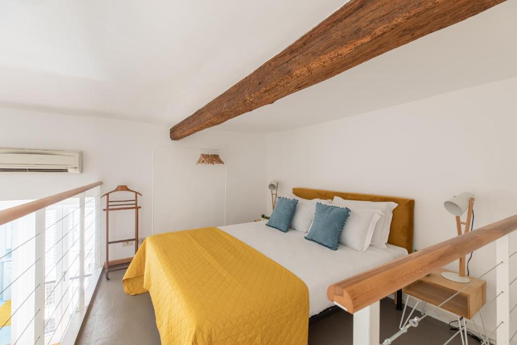 een slaapkamer met een bed met een gele deken bij iFlat Yellow Monti Studio Apartment in Rome