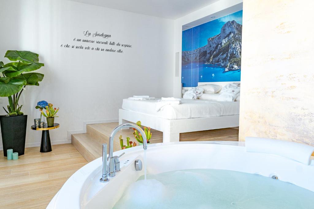 a bathroom with a tub and a bed in a room at Sunshine Charming Houses in Alghero
