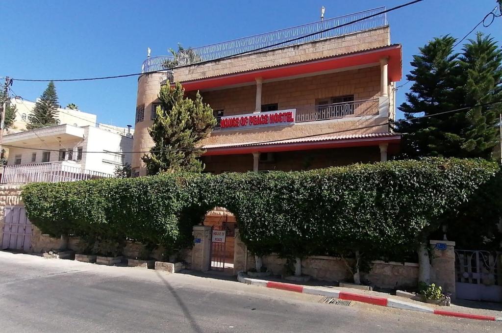 un edificio con setos frente a un edificio en House of Peace, en Bethlehem