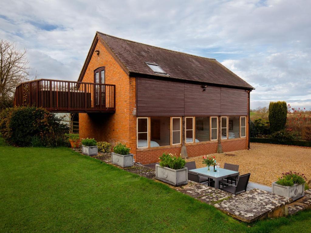 une maison avec une terrasse sur le côté dans l'établissement Granary at Rectory Farm, à Wolford