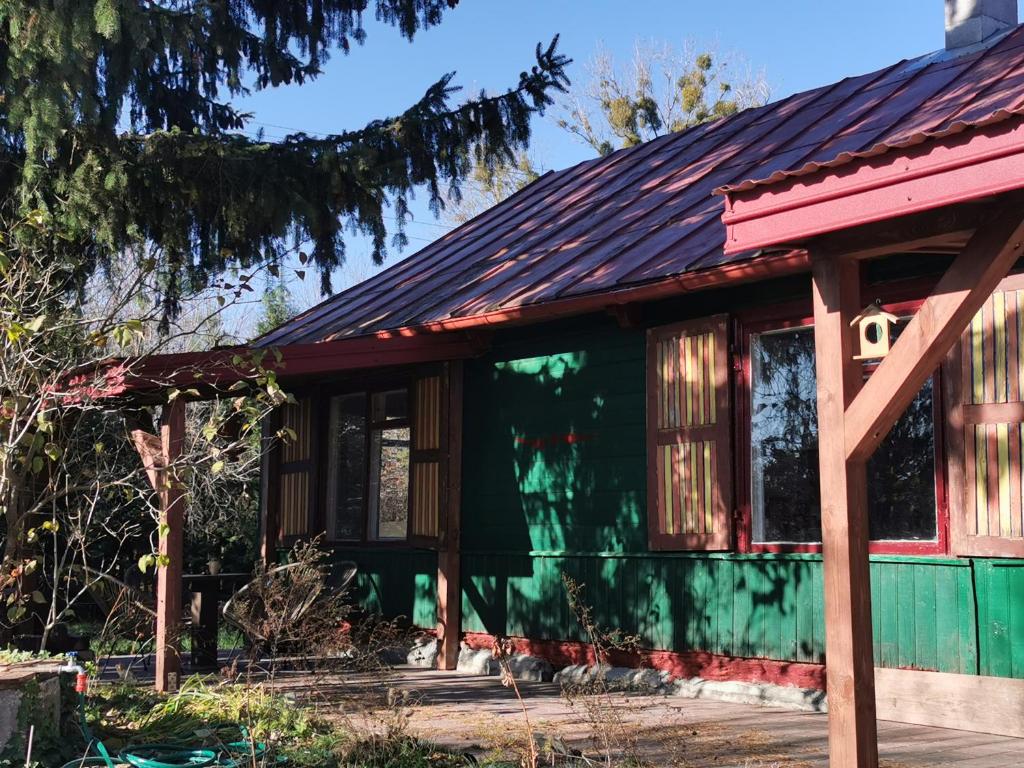 una pequeña casa verde con techo rojo en Buglandia, 