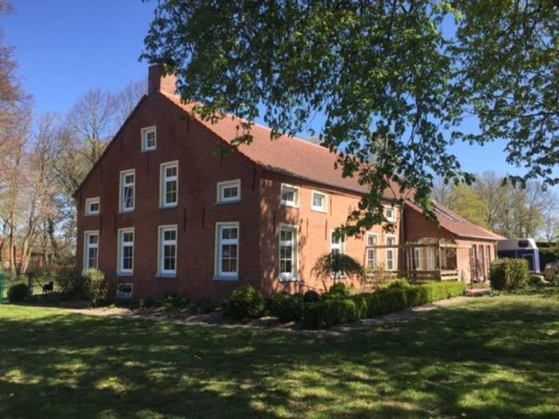 a large red brick house with a large yard at Ferienwohnung Roessing 25194 in Bunde