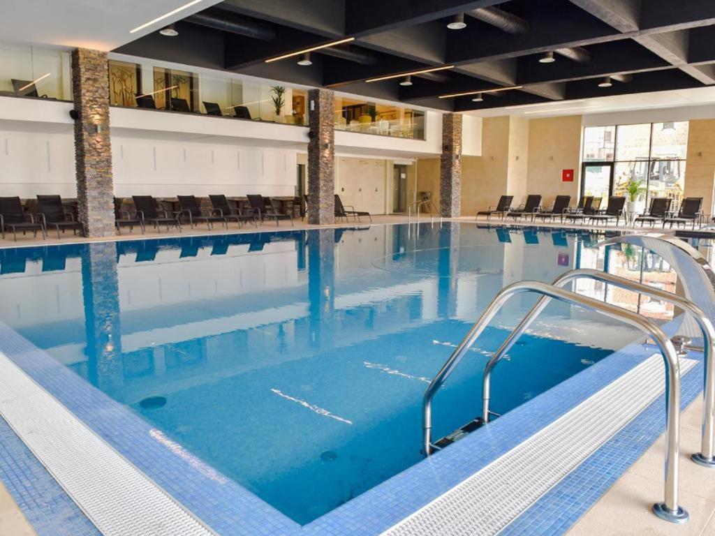a large indoor swimming pool with blue water at Apartman Grk 5 in Zlatibor