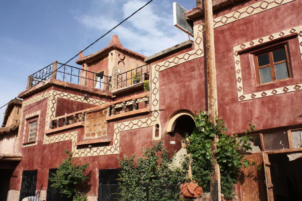 een oud rood gebouw met een balkon bij Room in Guest room - Gite Tawada - Haut-atlas - Room for 4 people in Agouti