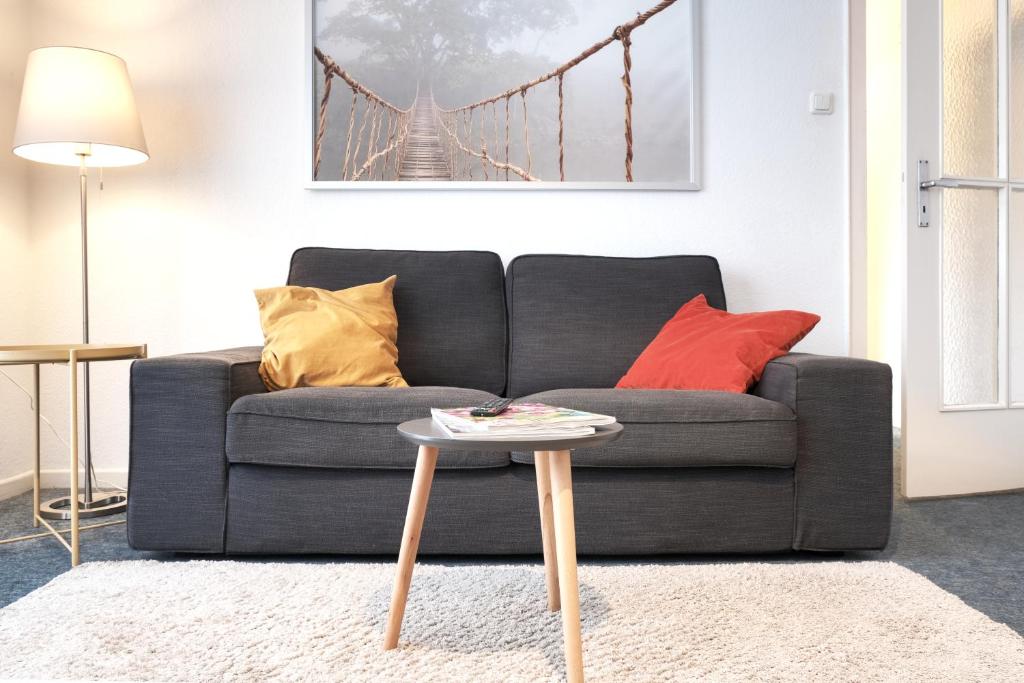 ein Wohnzimmer mit einem Sofa und einem Tisch in der Unterkunft Ferienwohnung Speldorf in Mülheim an der Ruhr