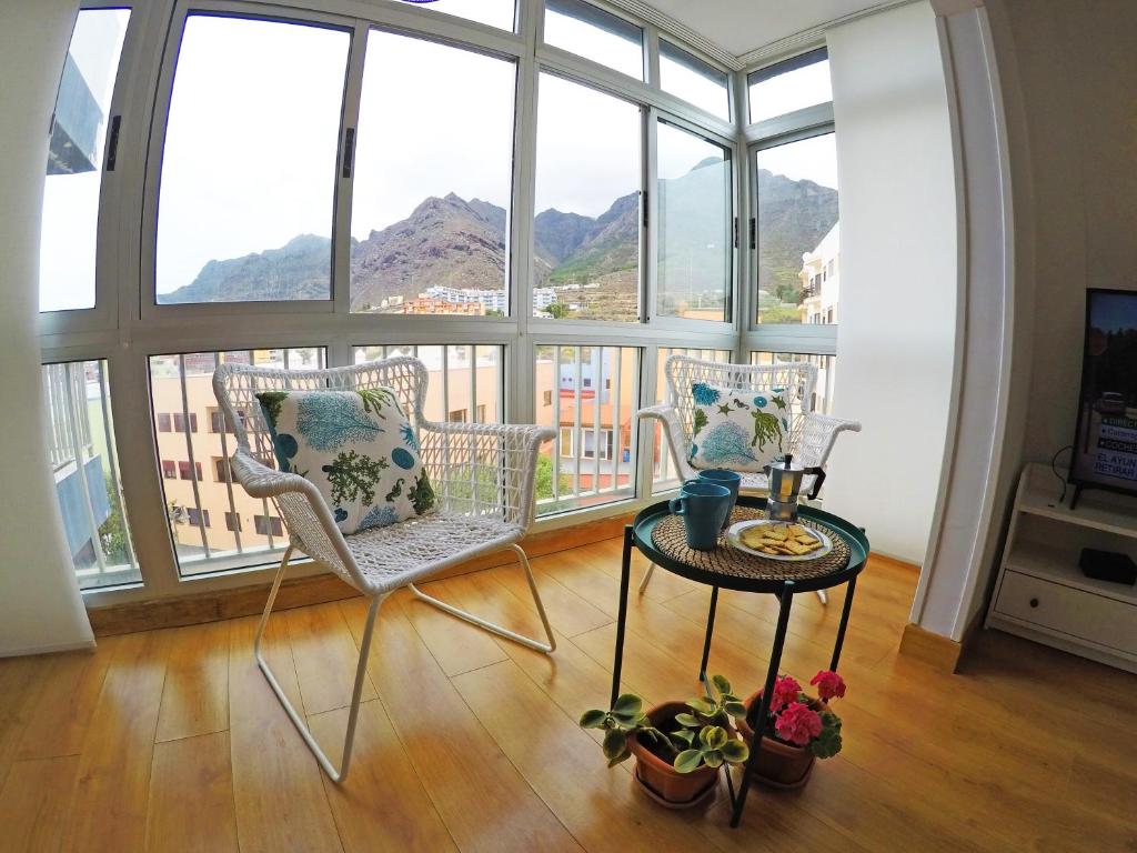 2 chaises et une table dans une chambre avec fenêtres dans l'établissement Apartamento La Paella de Bajamar, à Bajamar